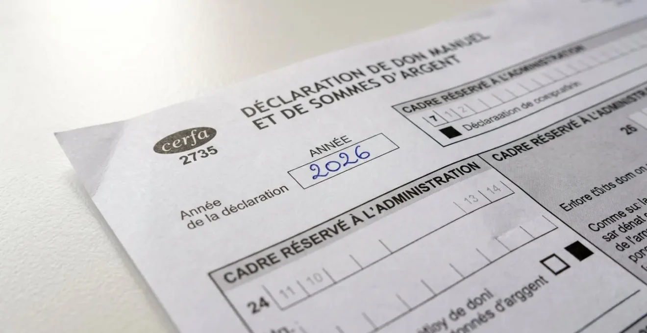Gros plan net d'un formulaire Cerfa de déclaration de donation posé sur une surface de bureau contemporaine blanche avec champs fiscaux visibles